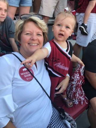 Kellie Knight poses with her granddaughter at a Razorback game.
