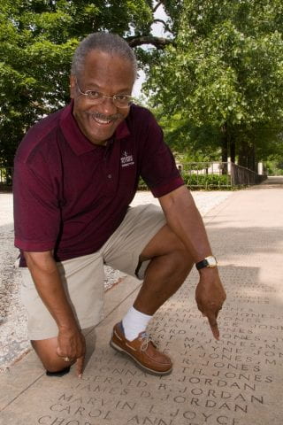 Gerald Jordan points to his name on Senior Walk
